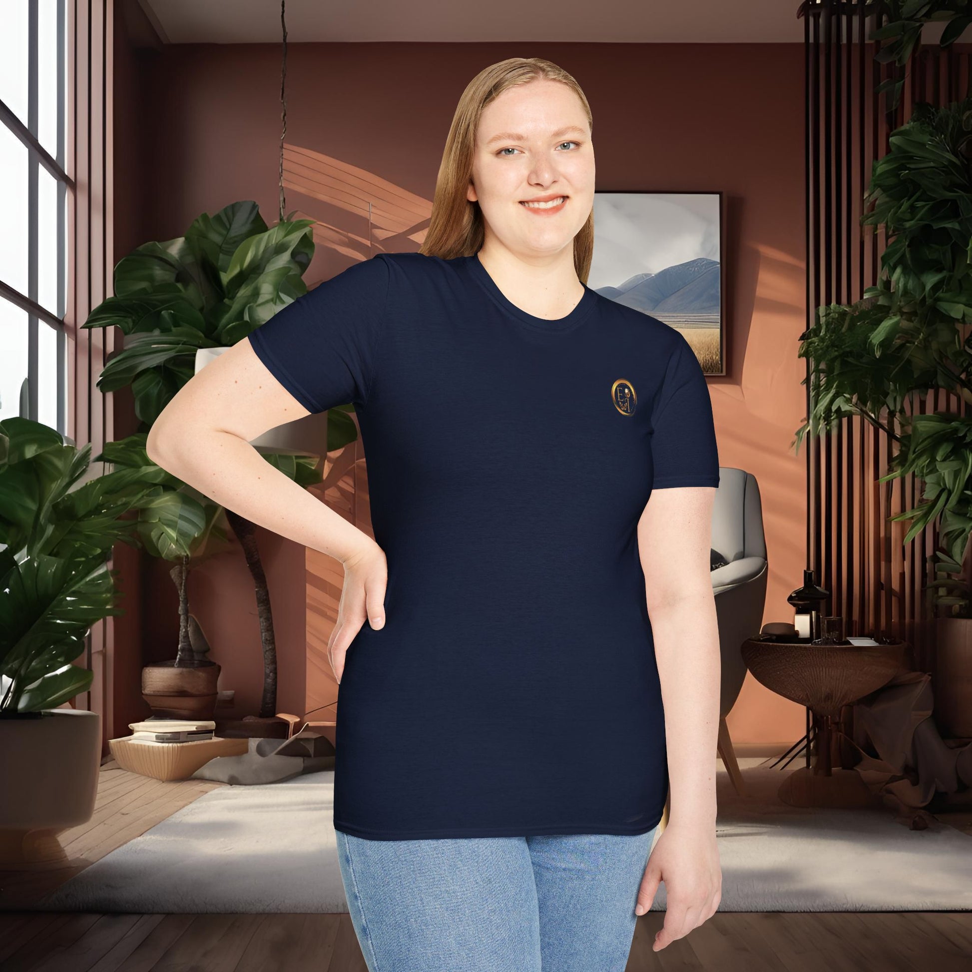 Person wearing a navy t-shirt with an Essence Innovation logo in a room with plants and decor