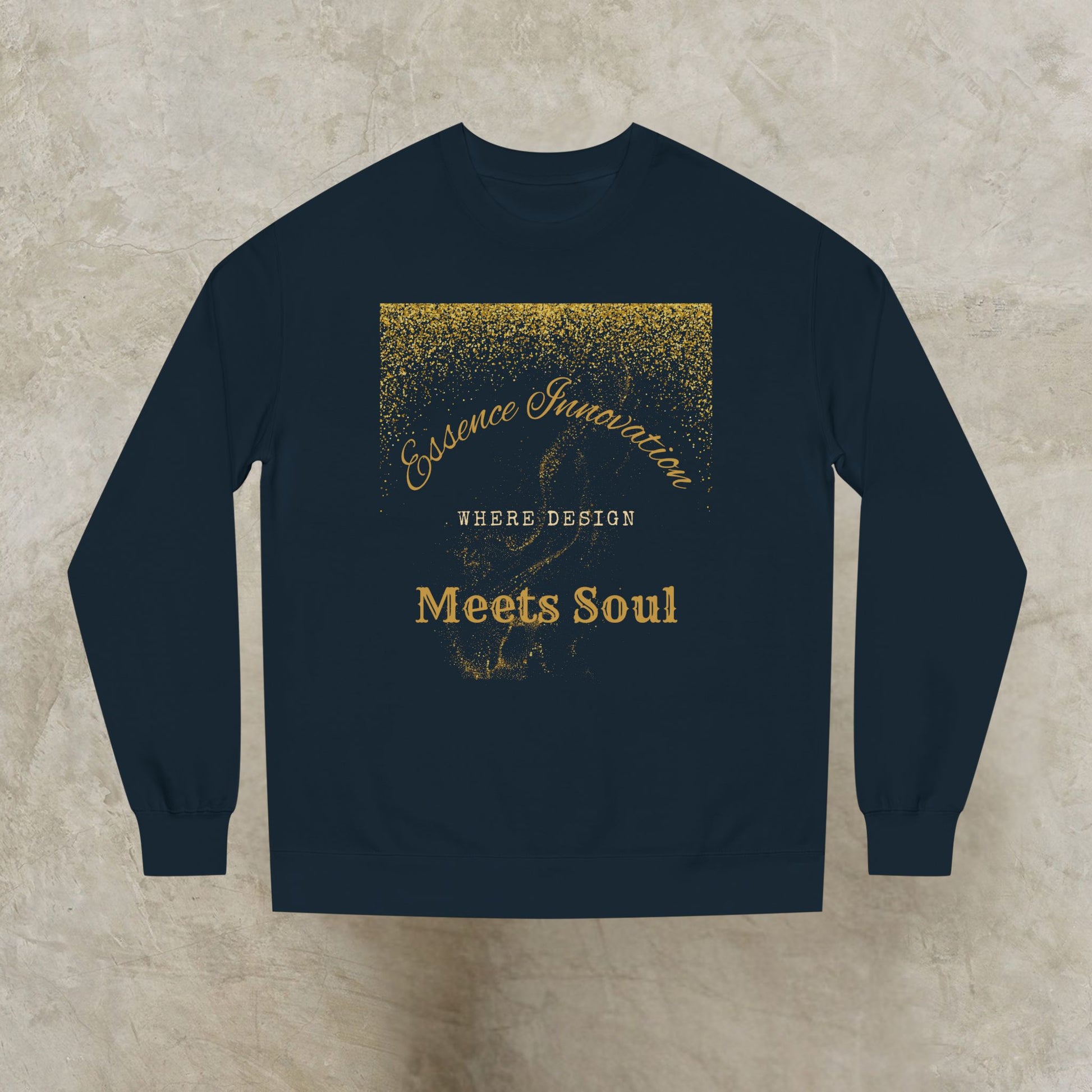 Black sweatshirt with gold Essence Innovation 'Design Meets Soul' text on a textured beige background