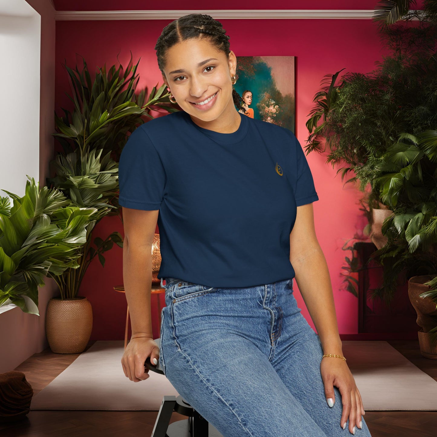 'EssenceInnoCreate' Woman sitting on a stool in a room with plants and a pink wall.