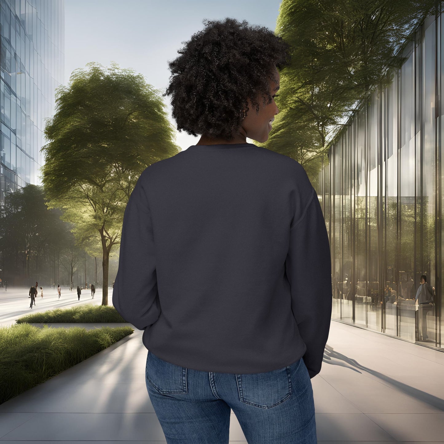 Person wearing a dark gray sweatshirt and blue jeans standing on a sidewalk with modern buildings and trees in the background.