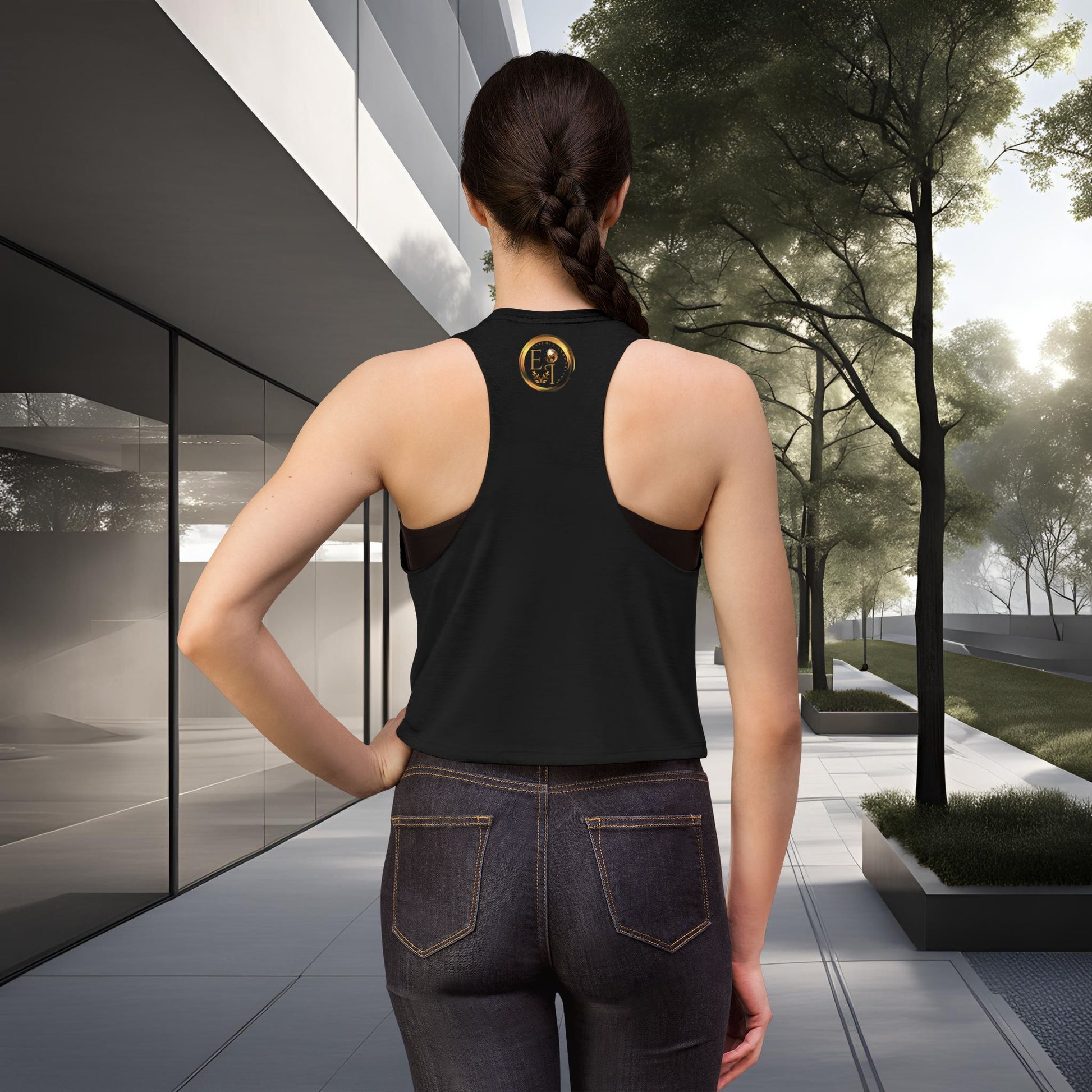 Person wearing a black Essence Innovation Bohemian Butterfly tank top with a logo, standing in an outdoor setting.
