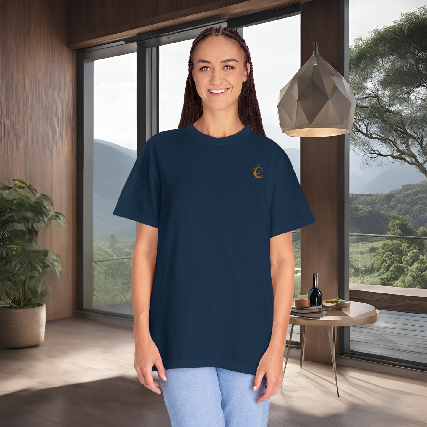 Woman wearing a navy blue t-shirt with a 'EssenceInnoCreate' yellow logo in a modern room with large windows.