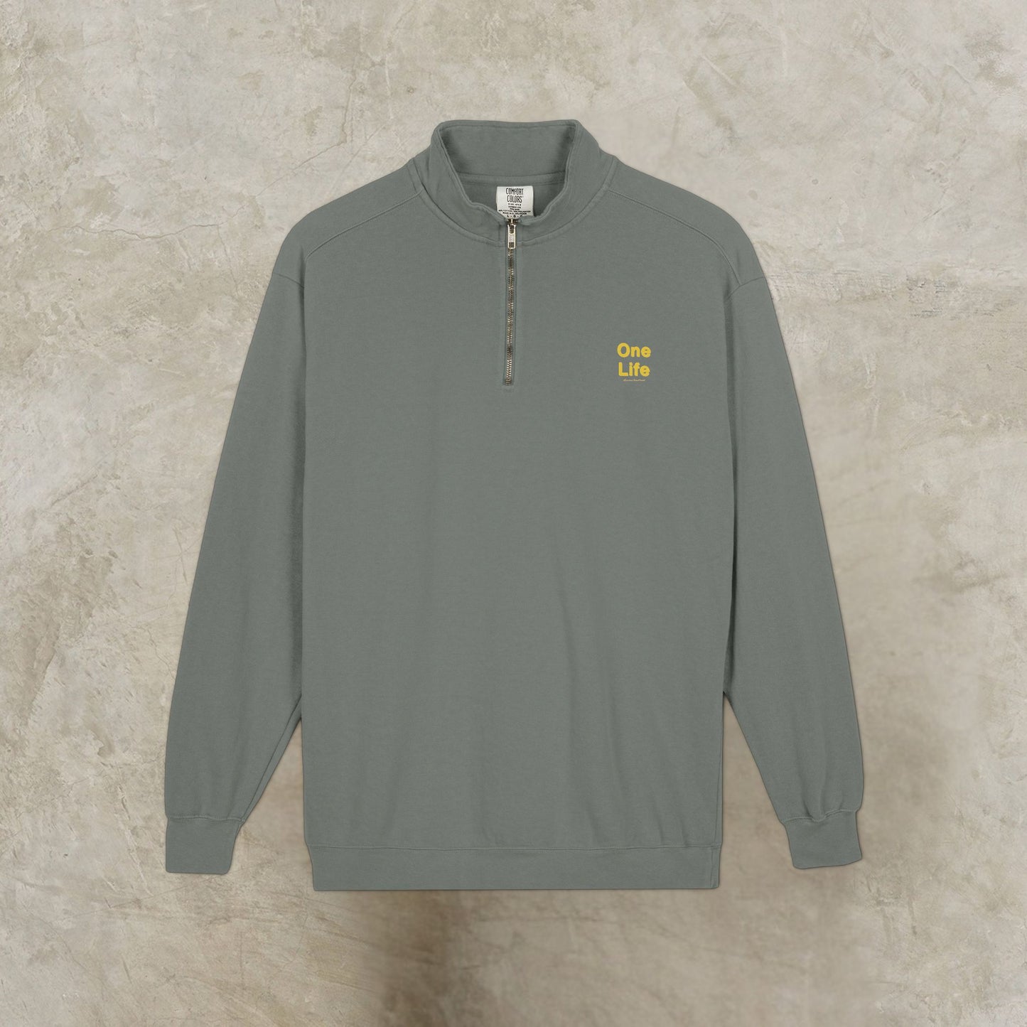 Gray sweatshirt with yellow One Life text on a beige background
