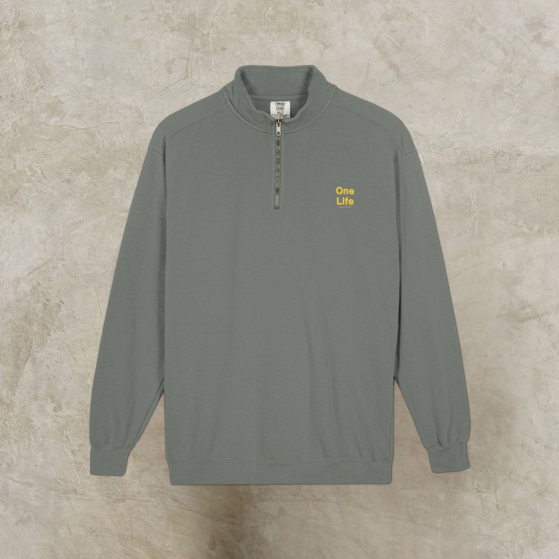 Gray sweatshirt with yellow One Life text on a beige background