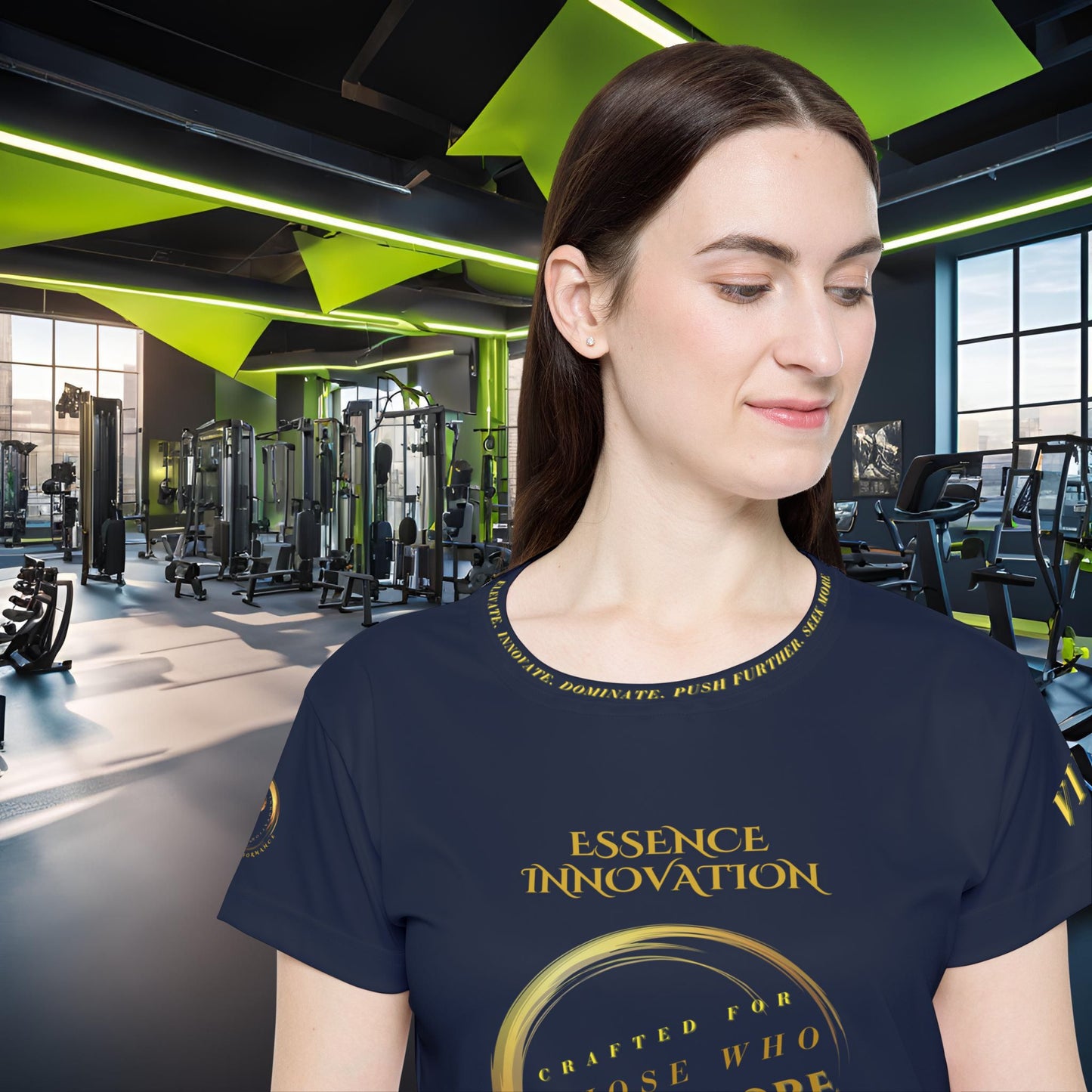 Woman wearing a navy blue t-shirt with gold Essence Innovation Seek More text in a gym setting