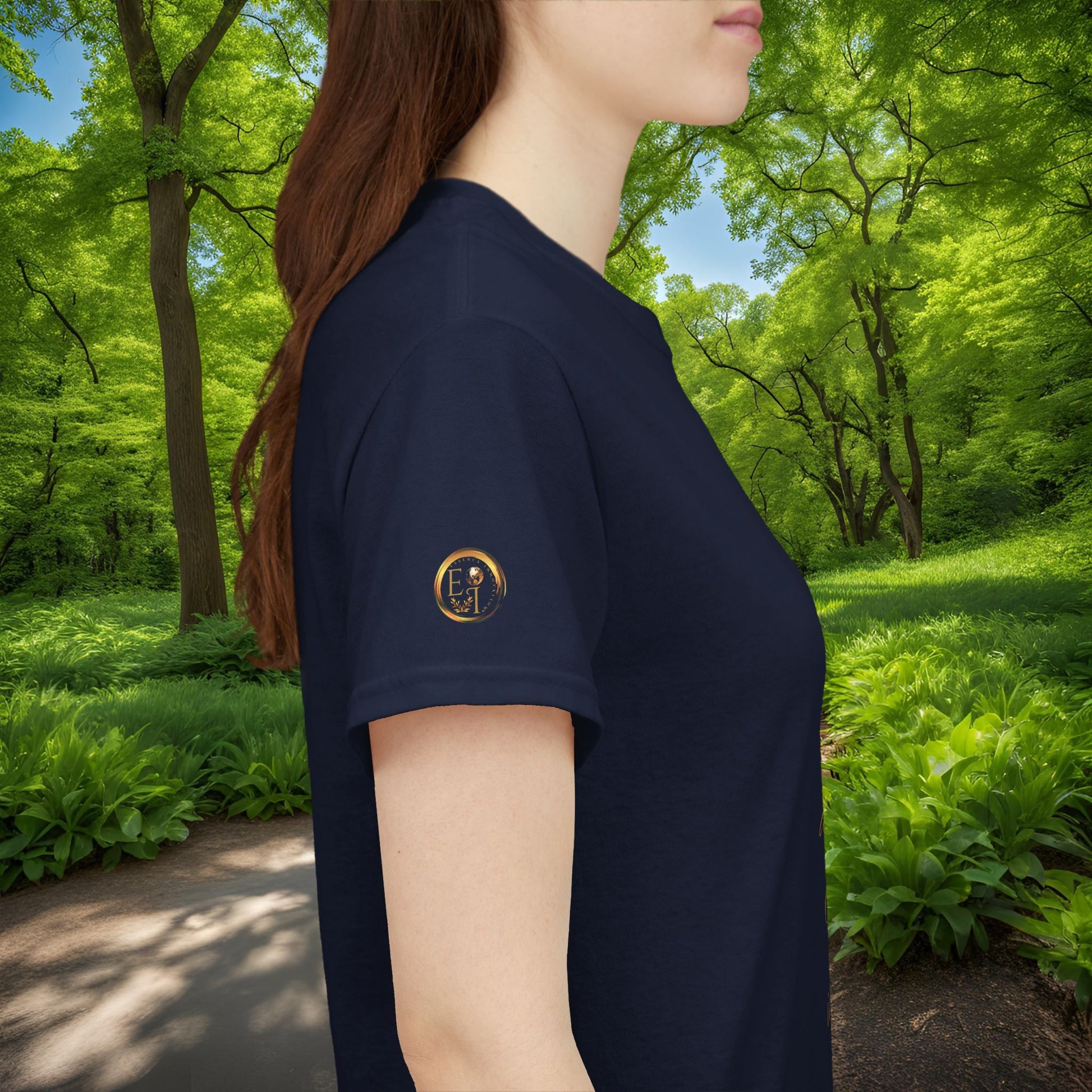 Person wearing a navy blue t-shirt with an Essence Innovation logo in a forest setting