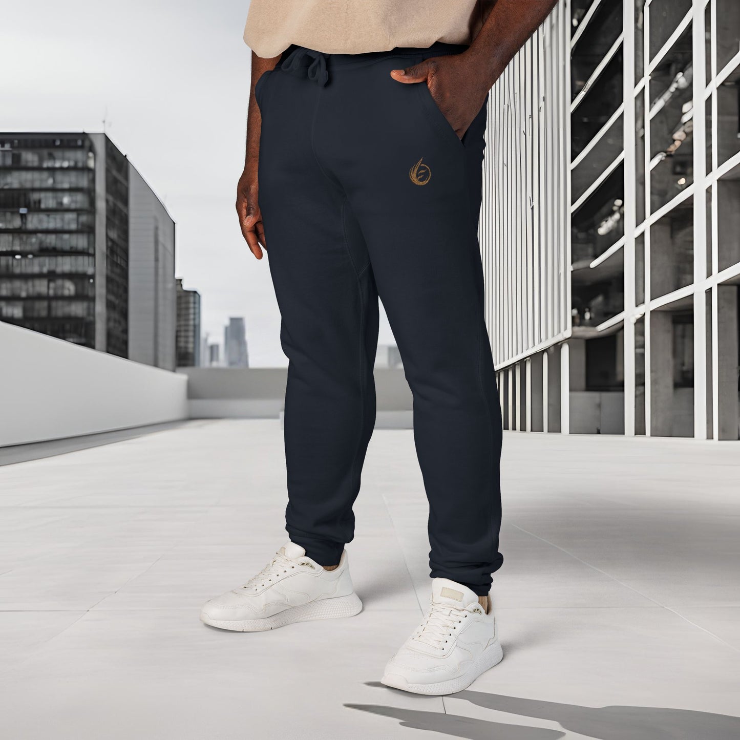 Person wearing navy 'EssenceInnoCreate' Quiet Resolve jogger pants and white sneakers standing on a rooftop with cityscape background