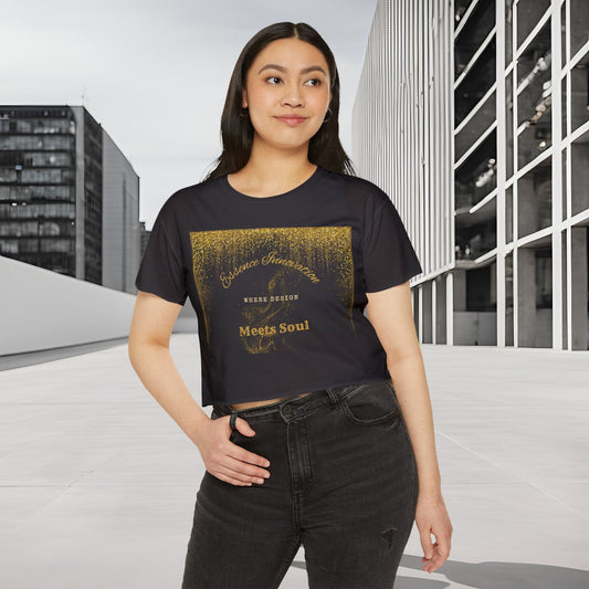 Woman wearing a black t-shirt with gold Essence Innovation 'Design Meets Soul' text in an urban setting
