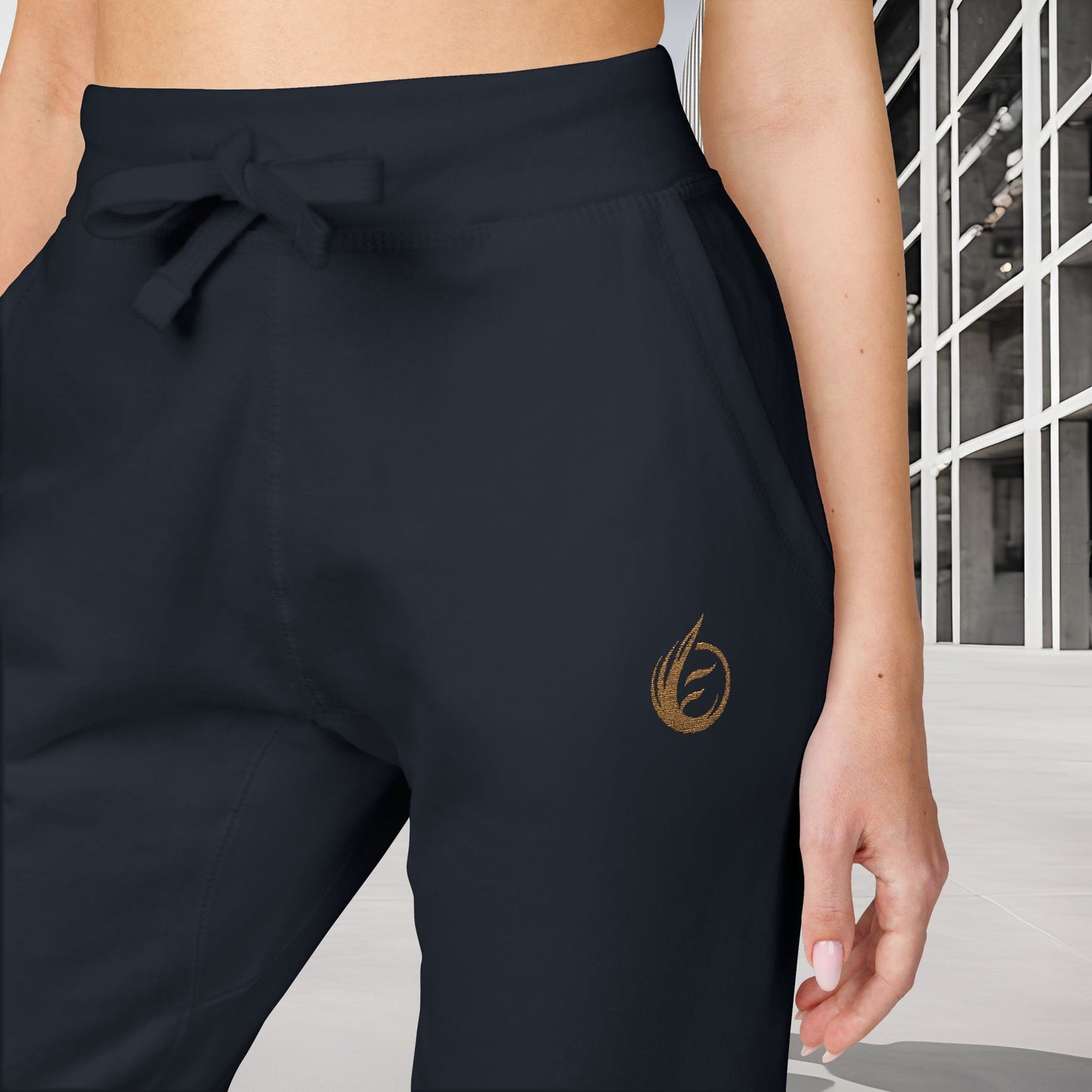 Navy 'EssenceInnoCreate' Quiet Resolve pants with a gold logo on a neutral background