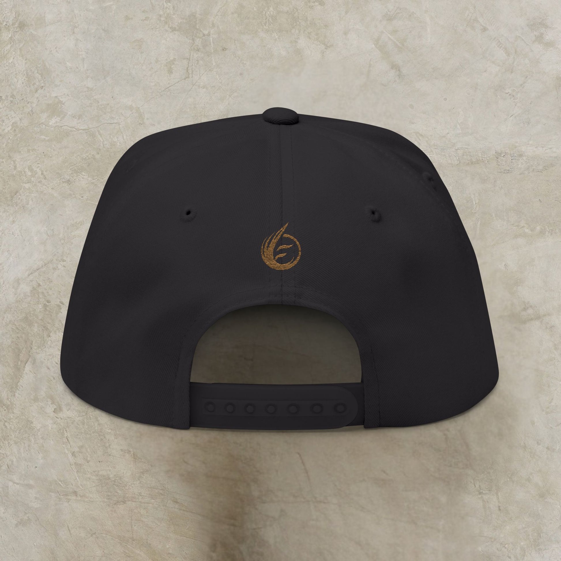 Black cap with a EssenceInnoCreate logo on the back against a beige background