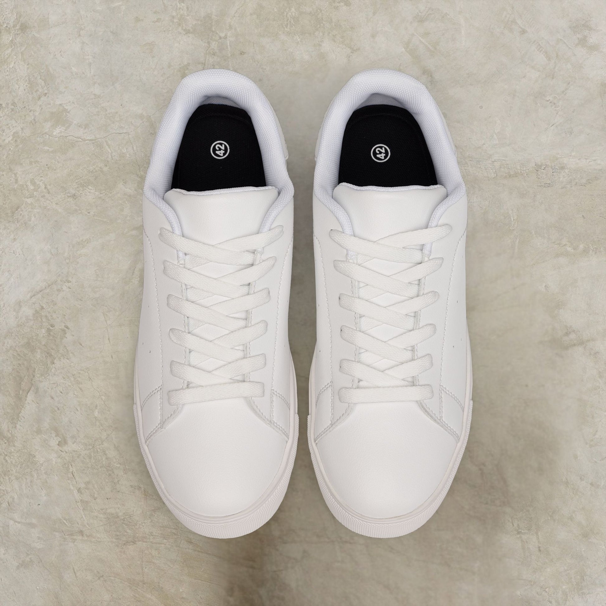 Pair of white EssenceInnoCreate sneakers on a light gray surface
