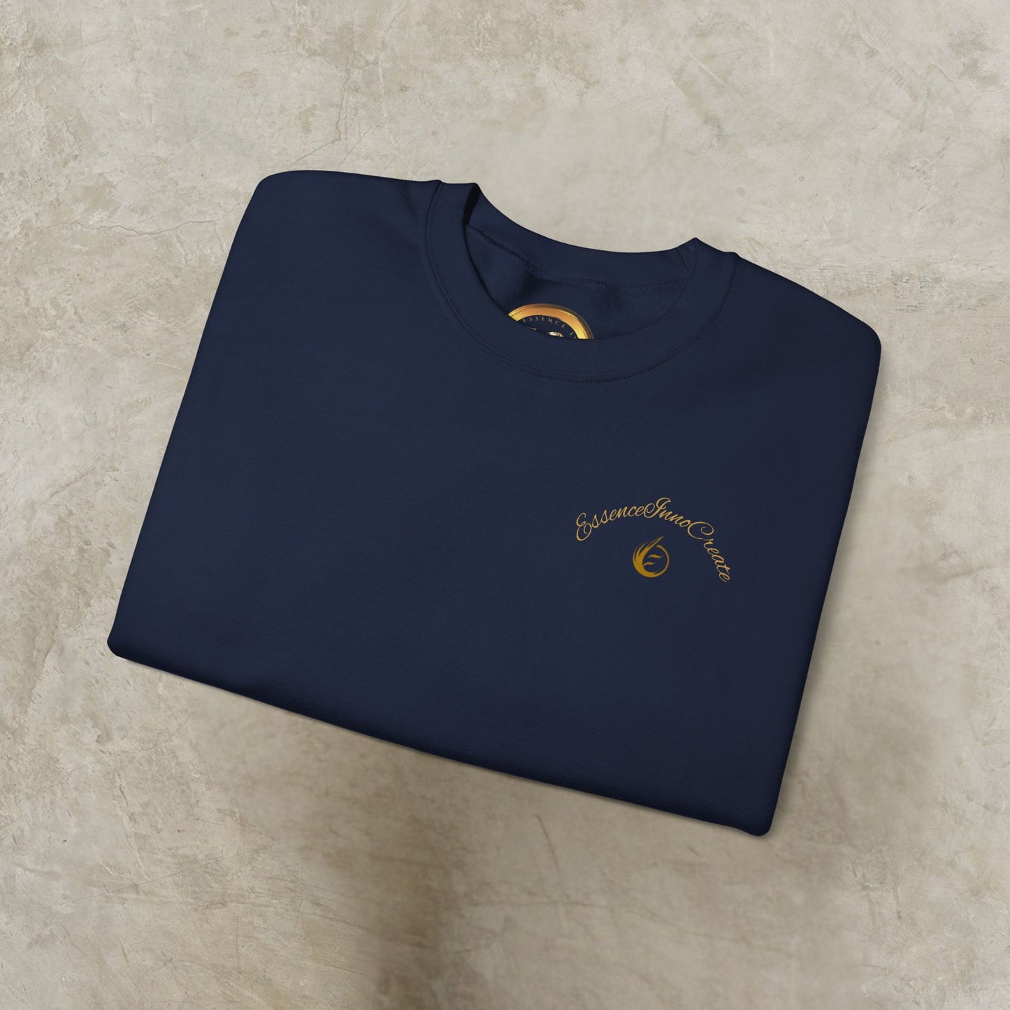 Folded navy blue sweatshirt with 'EssenceInnoCreate' logo on a beige surface