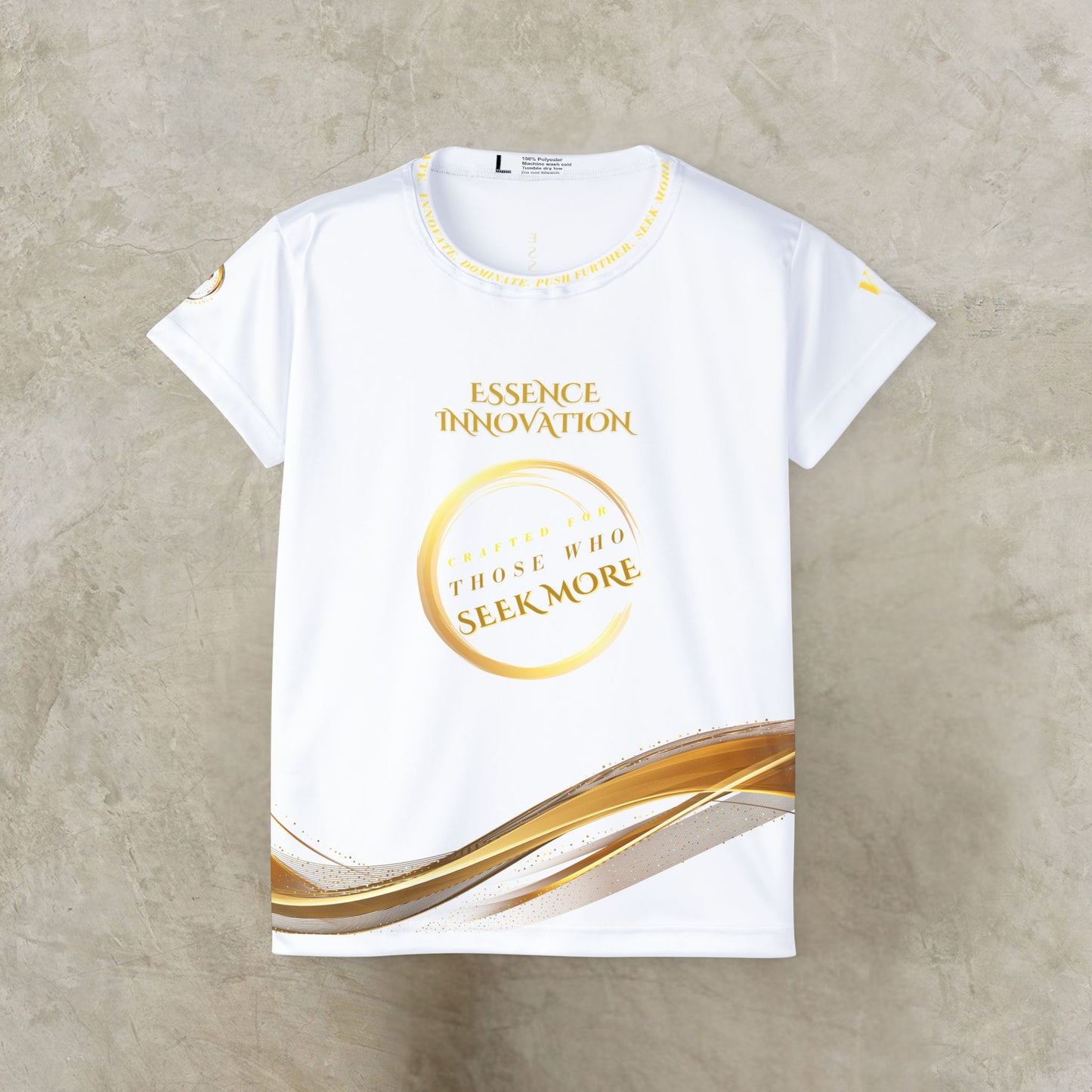 White t-shirt with gold Essence Innovation Seek More text and design on a beige background