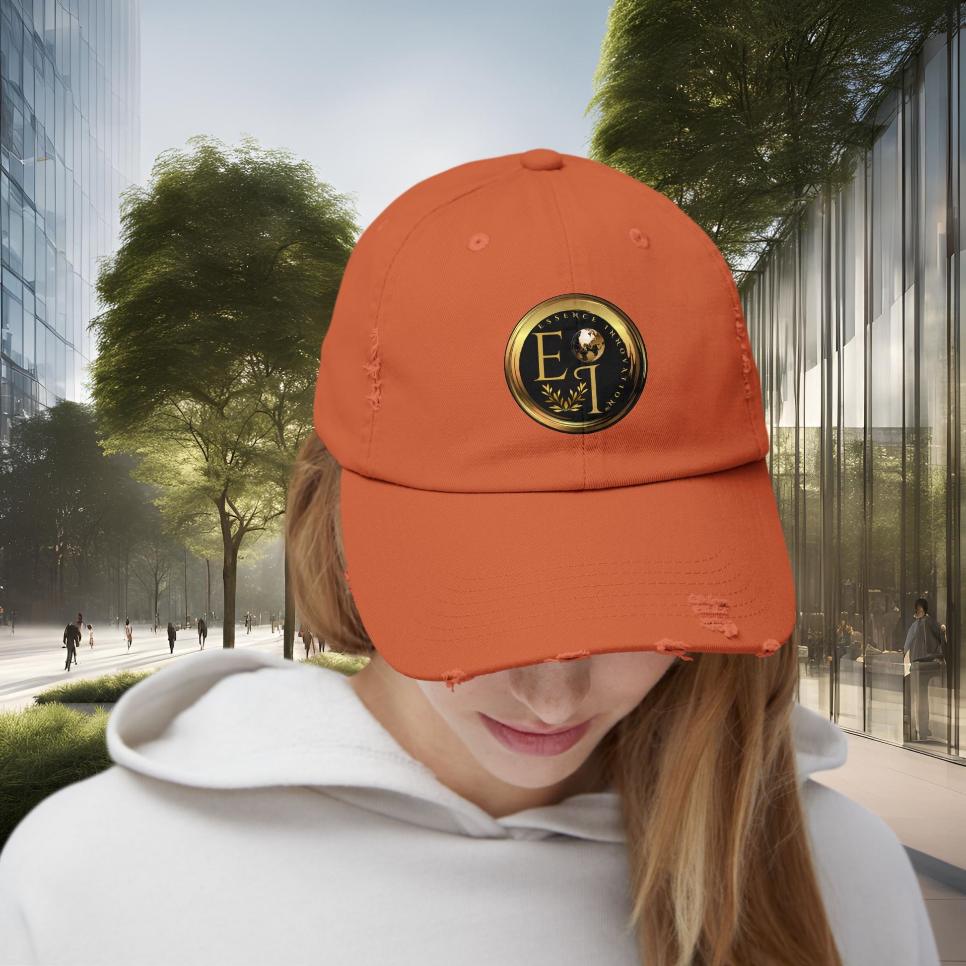 Person wearing an orange Essence Innovation cap with a logo in an urban setting