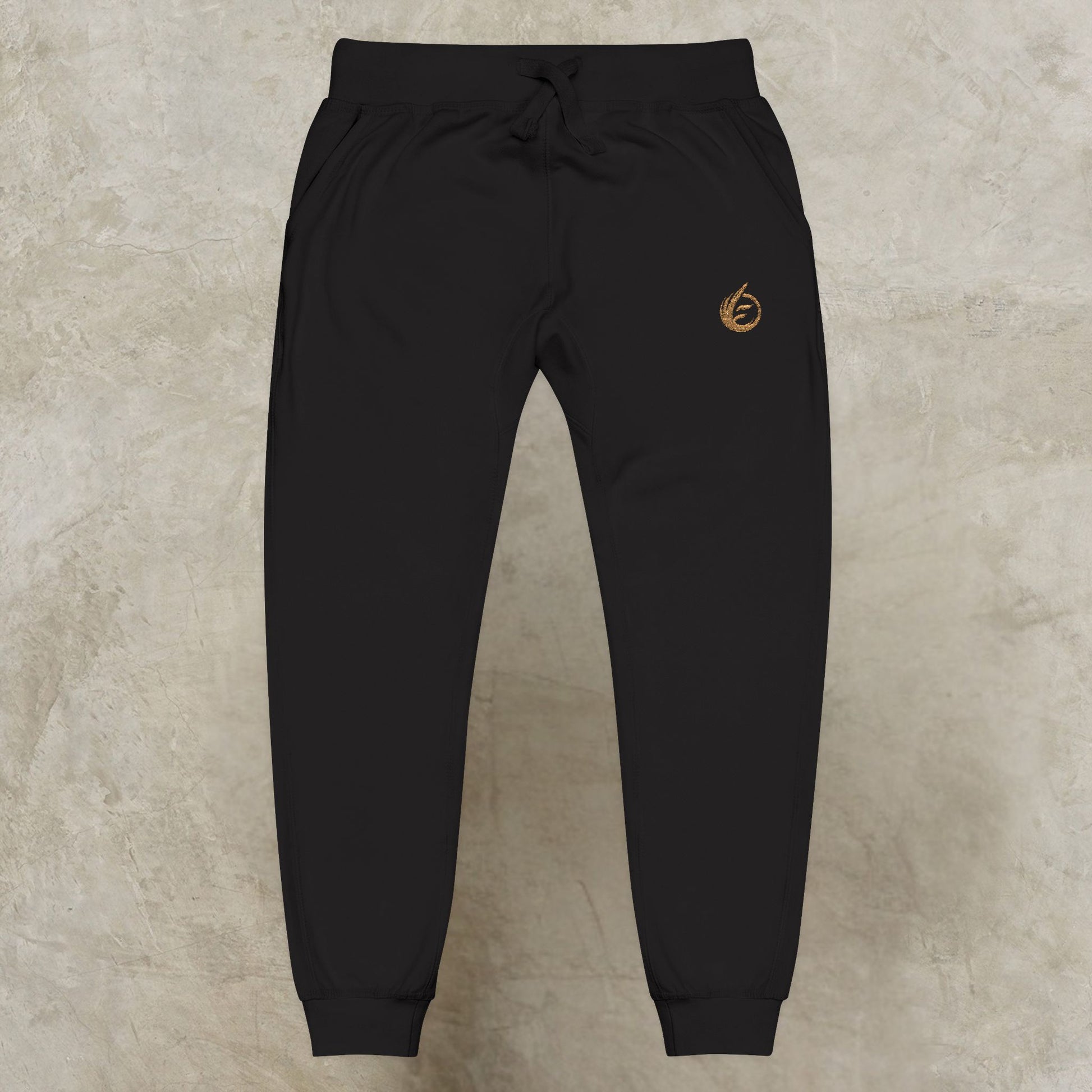 Black 'EssenceInnoCreate' Quiet Resolve jogger pants with a logo on a beige background