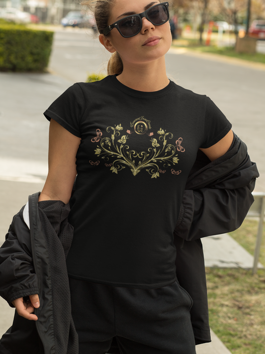 Woman wearing a black Bohemian Butterfly t-shirt with a decorative design outdoors.