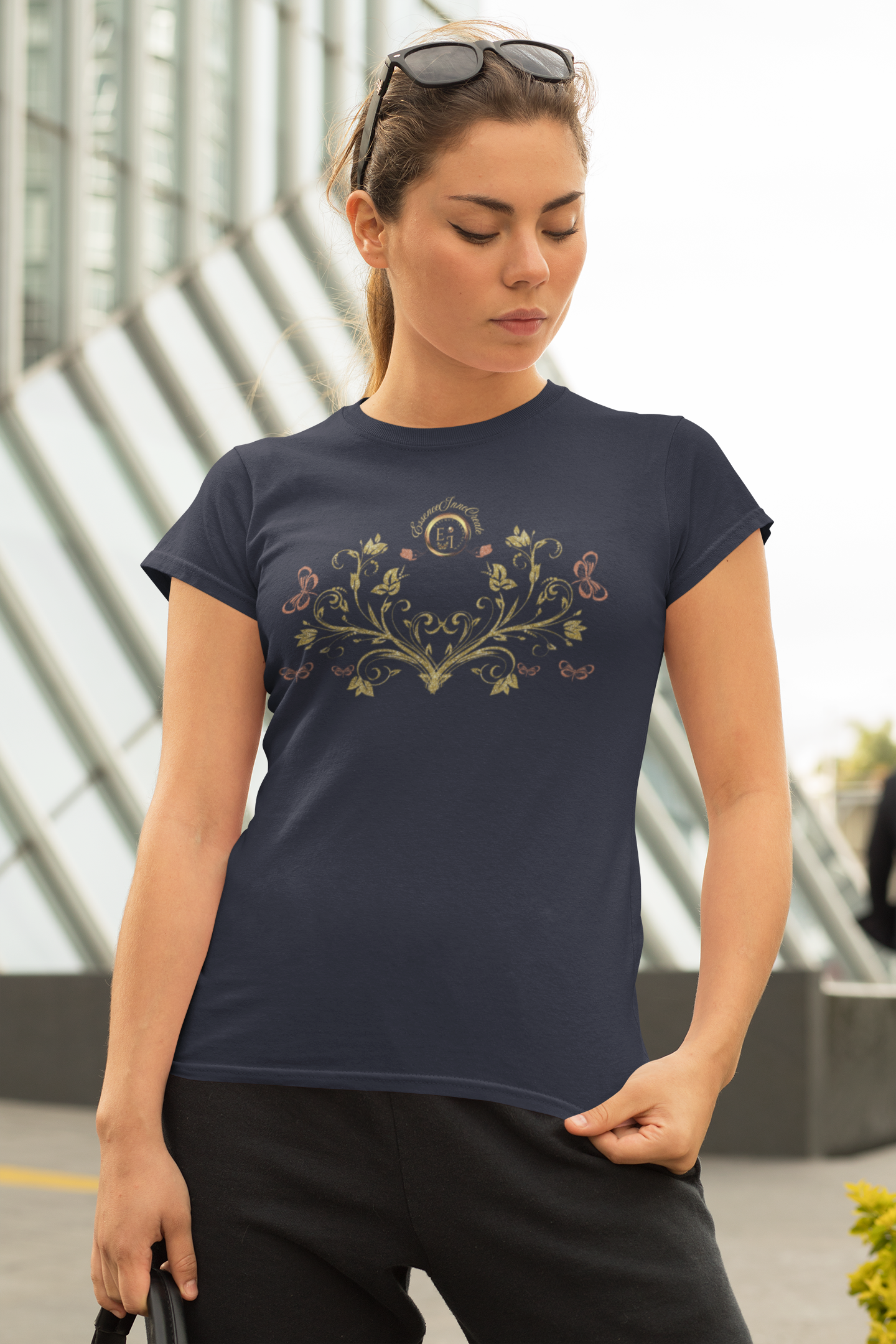 Woman wearing a navy blue Bohemian Butterfly t-shirt with a logo and text, standing outdoors.