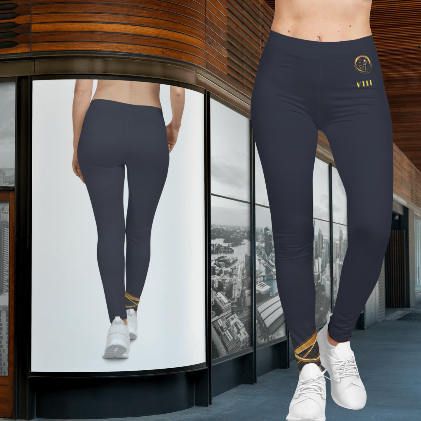 Person wearing dark blue Essence Innovation leggings with a logo, standing in front of a glass wall with cityscape view.