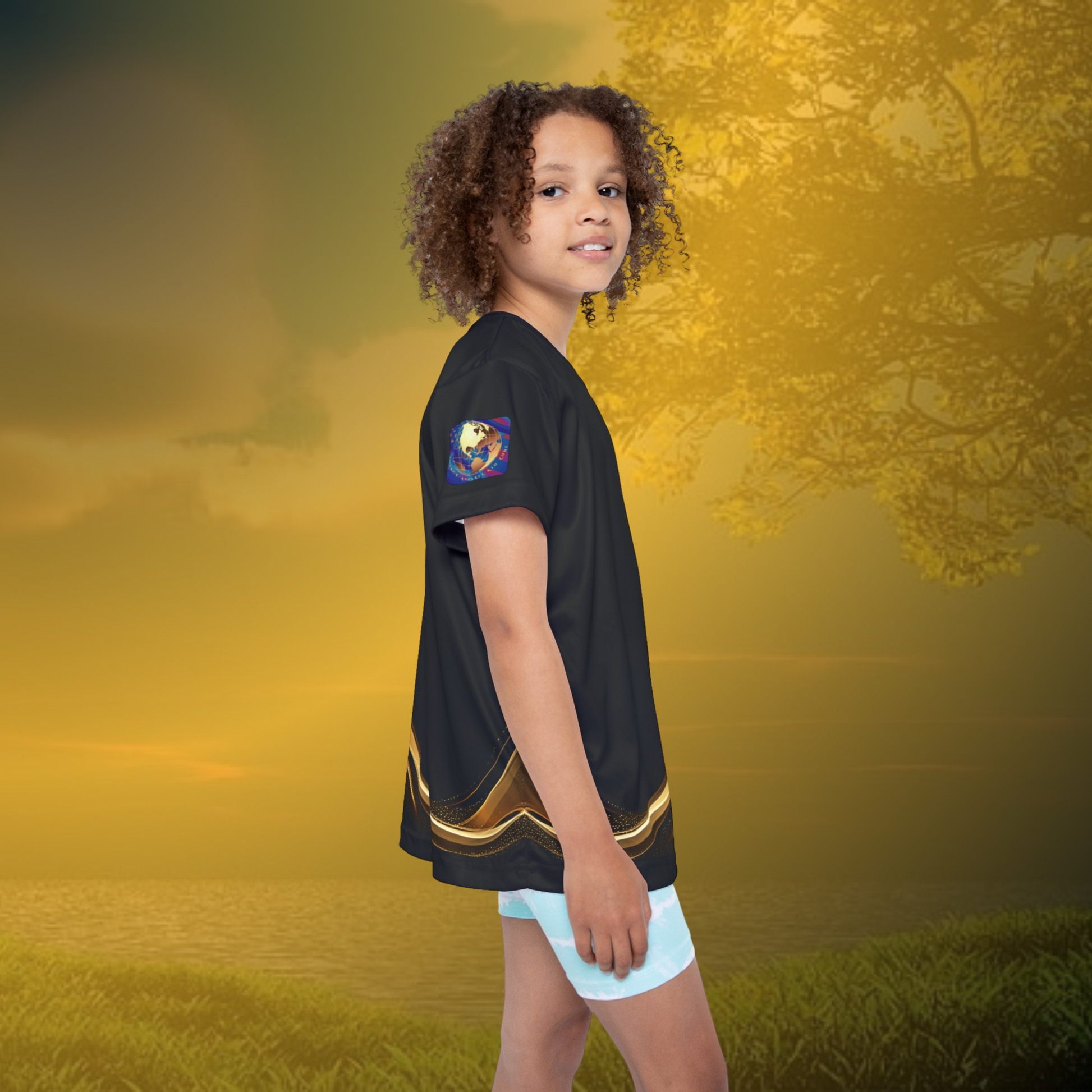 Child wearing a black Essence Innovation t-shirt with a gold design on a golden sunset background