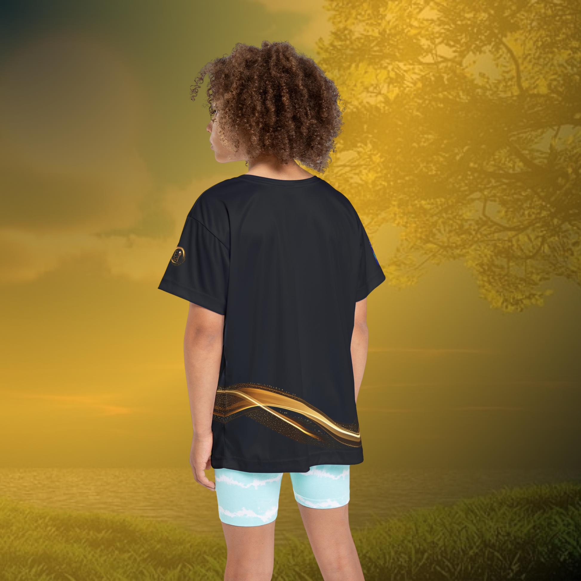 Child wearing a black Essence Innovation t-shirt with a gold design on a golden sunset background