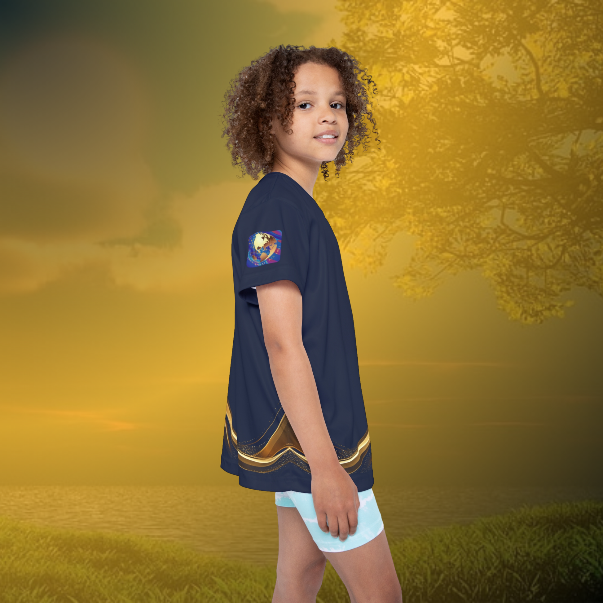 Child wearing a navy blue essence Innovation t-shirt with a gold stripe and light blue shorts on a white background