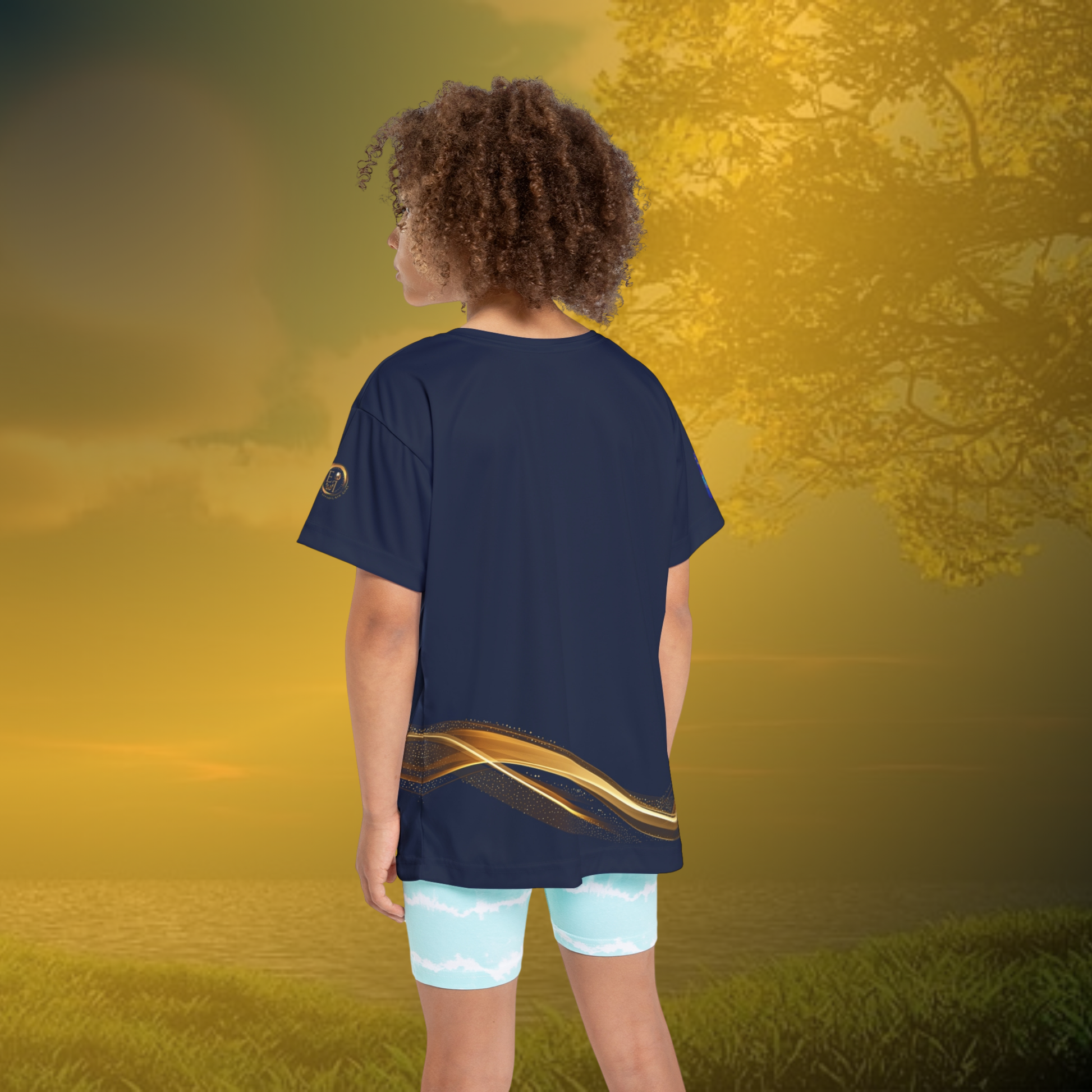 Child wearing a navy blue essence Innovation t-shirt with a gold stripe and light blue shorts on a white background