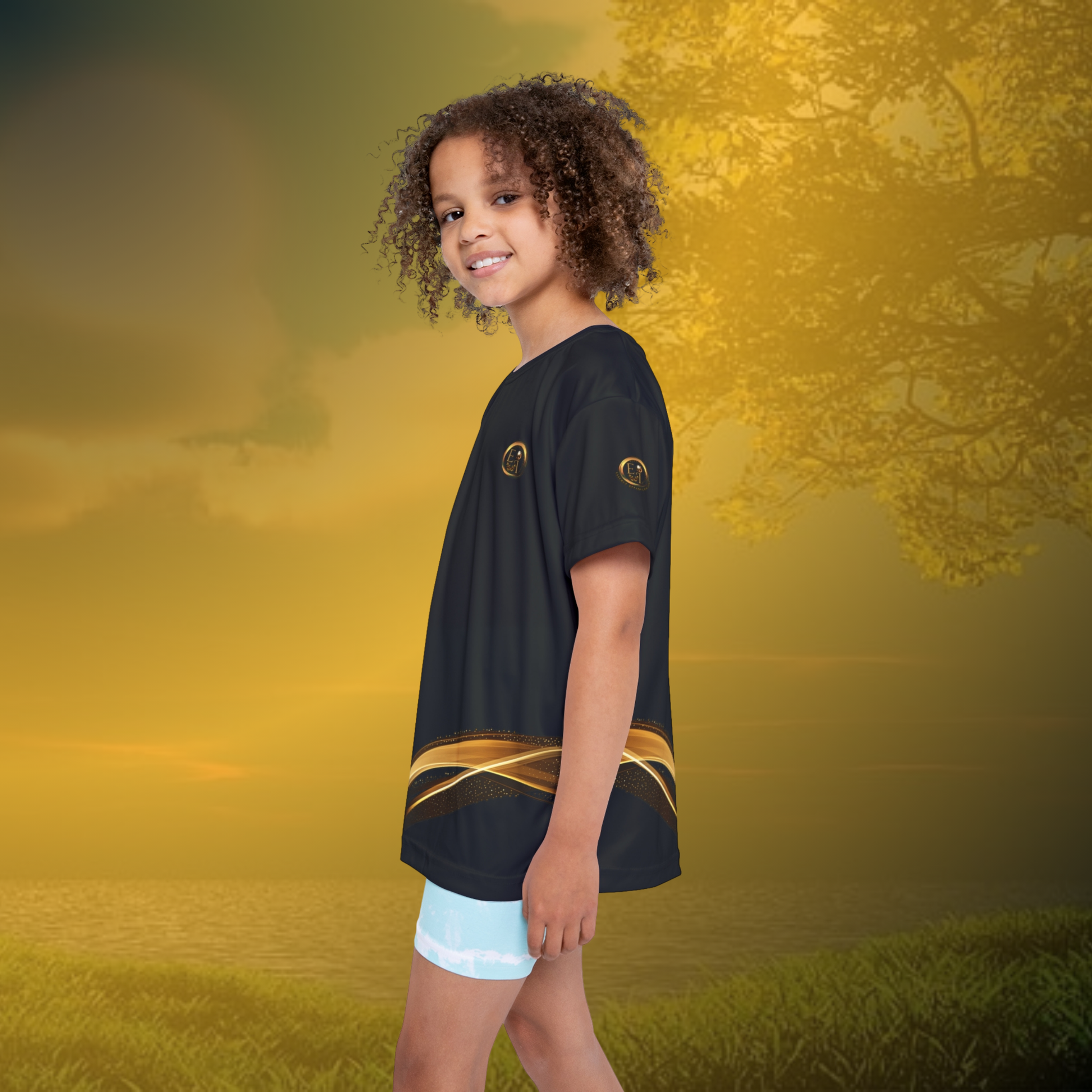 Child wearing a black Essence Innovation t-shirt with a gold design on a golden sunset background