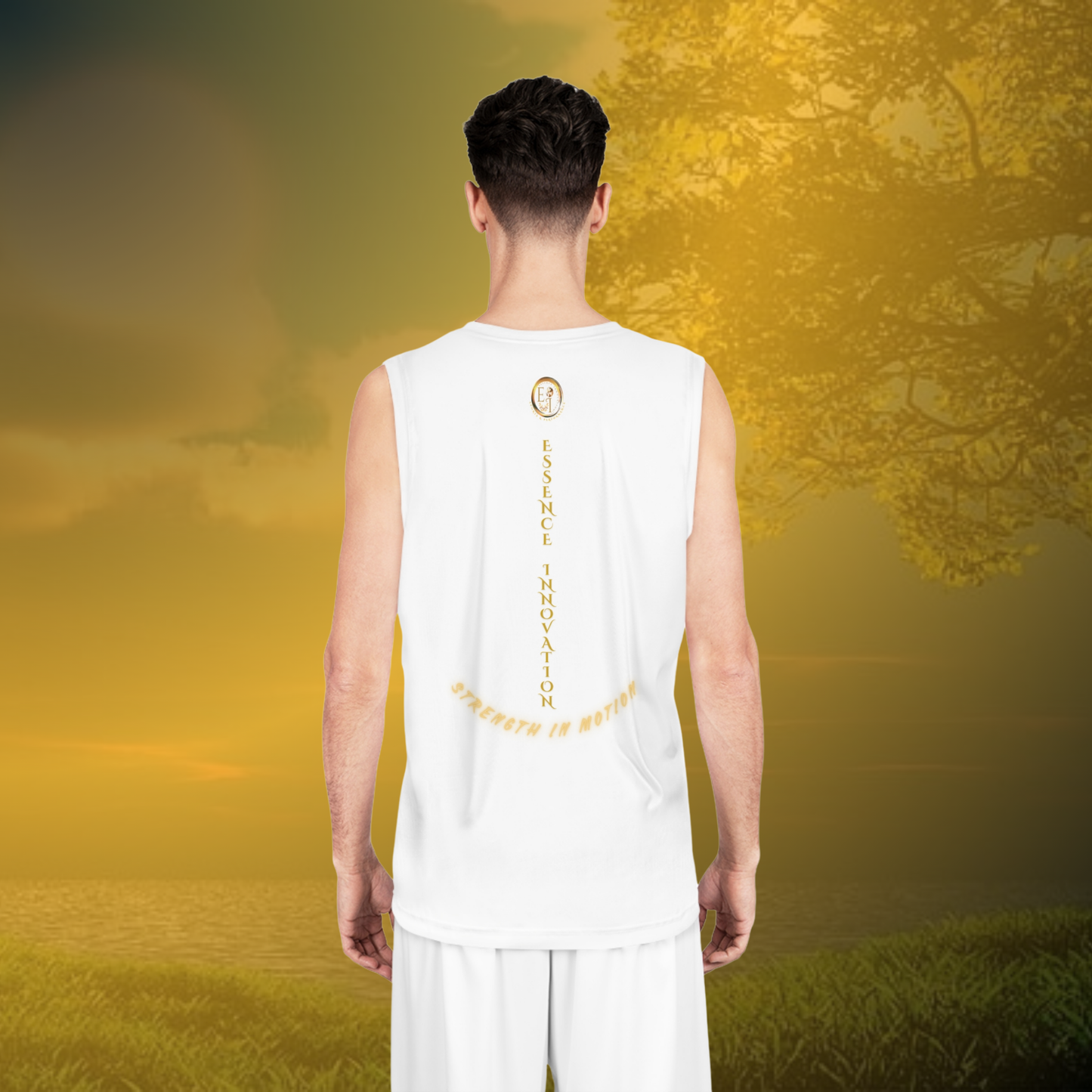 Person wearing a white sleeveless shirt with a gold design, standing in a field with trees and a sunset.