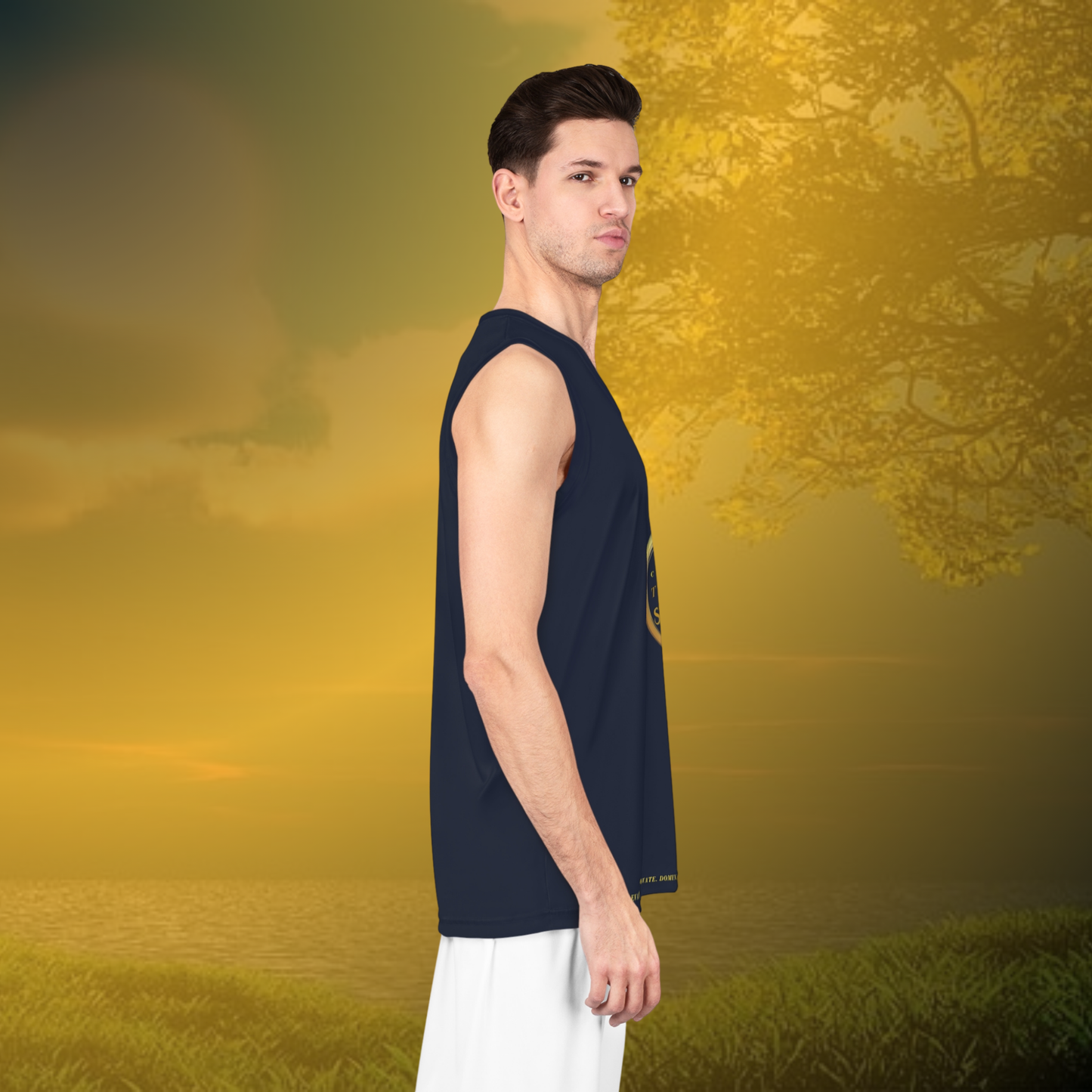 Man wearing a navy sleeveless shirt and white pants standing in a field with a blurred natural background
